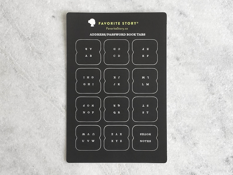 May include: Black address and password book tabs with white lettering. The tabs are labeled with letters of the alphabet and the word "NOTES". The text "FAVORITE STORY" and "FavoriteStory.co" are at the top.