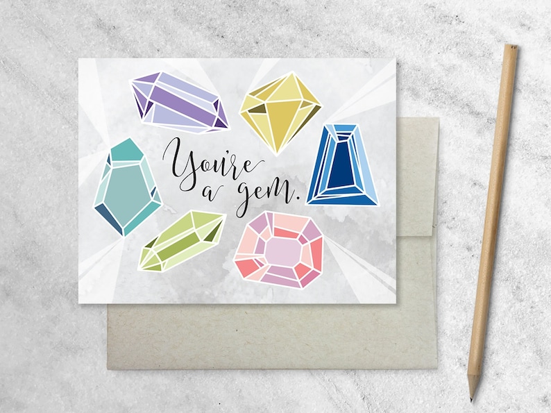 May include: A greeting card with a watercolor background and the text "You're a gem."  The card features seven colorful gemstones in various shapes.
