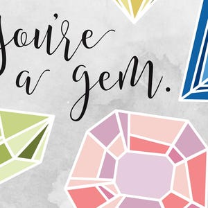 May include: A card with the text "You're a gem."  The card features a variety of colorful gemstones, including a pink, green, blue, and yellow gem.