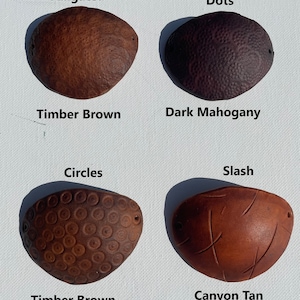 May include: Four leather eye patches in various shades of brown. The top left patch is Timber Brown with an alligator texture. The top right is Dark Mahogany with a dots texture. The bottom left is Timber Brown with a circles texture. The bottom right is Canyon Tan with a slash texture.