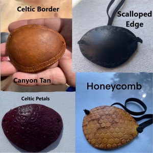 May include: Four leather eye patches with different designs. The top left is Canyon Tan with a Celtic Border. The top right is black with a Scalloped Edge. The bottom left is Celtic Petals. The bottom right is Honeycomb.