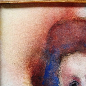 May include: A close-up of a watercolor painting of a person's face. The person has red-brown hair and blue eyes. The background is a soft, light brown.