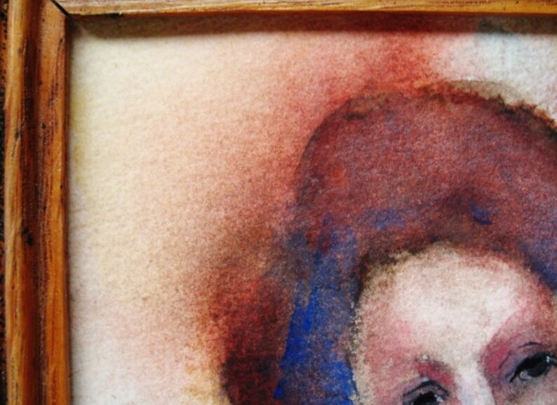May include: A close-up of a watercolor painting of a person's face. The person has red-brown hair and blue eyes. The background is a soft, light brown.