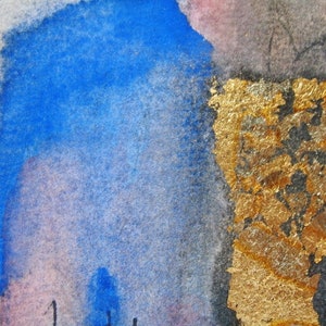 May include: Abstract watercolor painting with blue and gold accents. The blue paint is in a loose, flowing style, while the gold is applied in a more textured, layered way. The painting has a sense of movement and energy.