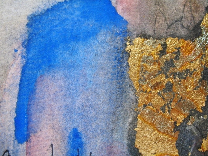 May include: Abstract watercolor painting with blue and gold accents. The blue paint is in a loose, flowing style, while the gold is applied in a more textured, layered way. The painting has a sense of movement and energy.