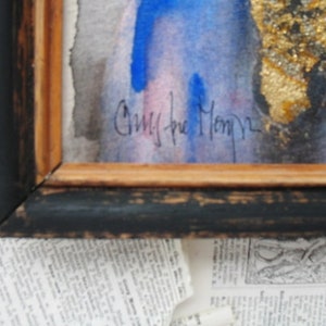 May include: A framed watercolor painting with a blue and pink background. The painting is signed "Chris the Monkey".