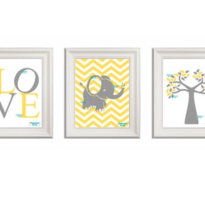 May include: Three framed prints with a yellow and gray color scheme. The first print features the word "LOVE" in yellow and gray letters. The second print features a gray elephant on a yellow chevron background. The third print features a gray tree with yellow leaves on a white background.