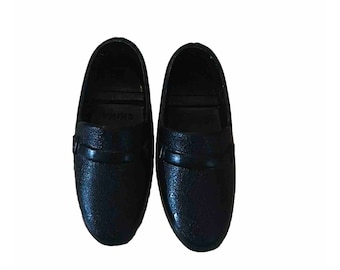 May include: A pair of black leather loafers with a buckle detail. The shoes have a textured leather upper and a smooth leather sole.