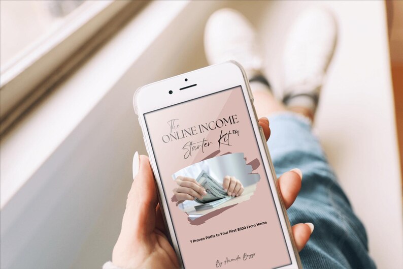 May include: A white smartphone displays a screen with the text "The Online Income Starter Kit" and an image of hands holding money. The phone is held by a person wearing blue jeans. The text below reads "7 Proven Paths to Your First $100 From Home."