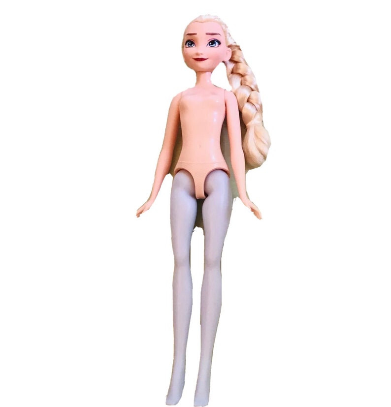 K&ouml;nnte beinhalten: Eine Plastikpuppe mit blonden Haaren, die zu einem Zopf geflochten sind. Die Puppe tr&auml;gt eine hellgraue Strumpfhose.