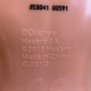 May include: Close-up of a doll's foot with the text #E8041 00591, &copy;Disney Hasbro SA, &copy;2018 Hasbro, Made in China, C-031G, and a CE mark.