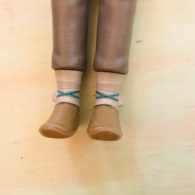 May include: A pair of brown boots with white socks and blue laces. The boots are worn and have a slightly scuffed appearance.