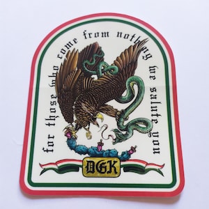 May include: A white sticker with a red, green, and white border. The sticker features a stylized image of an eagle and a snake fighting over a cactus. The text "for those who come from nothing we salute you" is written around the image. The text "DGK" is written in gold on a black banner.
