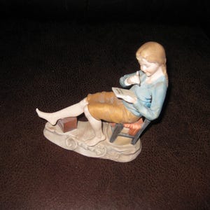 FIGURA DE PORCELANA Niña joven sentada en silla con respaldo inclinado escribiendo una carta (marca del fabricante Kalk o Arnart) 5 3/4" de pie descalzo hasta la espalda 6 3/4" de alto