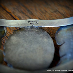 Puede incluir: Una pulsera de plata con un dise&ntilde;o floral y la inscripci&oacute;n "STERLING 925" en la parte posterior.