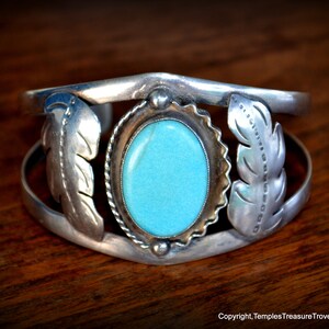 Puede incluir: Un brazalete de plata con una piedra turquesa y dise&ntilde;os de plumas. El brazalete est&aacute; hecho de plata de ley y tiene un estilo tradicional nativo americano.