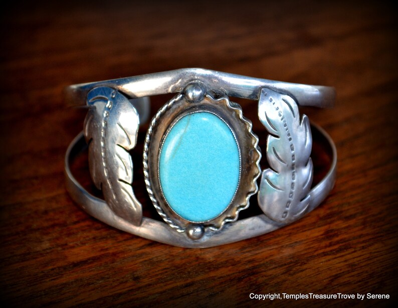 Puede incluir: Un brazalete de plata con una piedra turquesa y dise&ntilde;os de plumas. El brazalete est&aacute; hecho de plata de ley y tiene un estilo tradicional nativo americano.