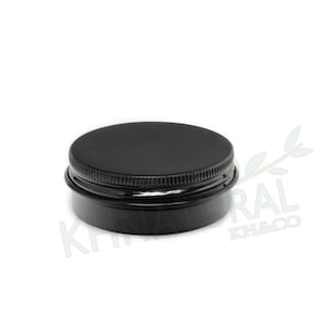 May include: A black metal jar with a black lid. The jar is round and has a smooth surface.
