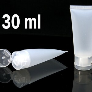 May include: Two clear plastic tubes with flip tops. One tube is lying down with the top open. The other tube is standing upright. Both tubes are labeled "30 ml".