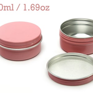 May include: Three pink metal tins with silver lids. The tins are 50ml or 1.69oz in size.