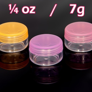 May include: Three small, clear plastic containers with lids. The lids are in different colours: yellow, pink, and purple. The containers are labelled "1/4 oz / 7g".