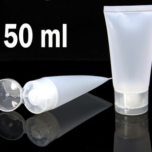 May include: Two clear plastic squeeze bottles with flip tops. One bottle is lying down with the top open. The other bottle is standing upright. Both bottles are labeled "50 ml".