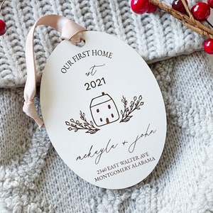 May include: White oval ornament with the text "Our First Home est 2021" and a house illustration. Below the house is the text "mackayla + john" and the address "2340 East Walter Ave Montgomery Alabama".