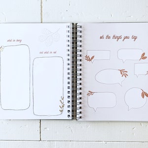 May include: A blank journal with a white cover and a spiral binding. The left page has the text "what I'm loving" and "and what I'm not" with blank spaces for writing. The right page has the text "oh the things you say" with several blank speech bubbles.