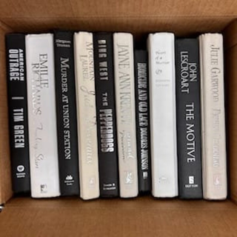 Puede incluir: Una colecci&oacute;n de diez libros de tapa dura con cubiertas blancas y negras. Los t&iacute;tulos incluyen "Outrage", "Murder at Union Station", "The Pepperdogs", "Homicide and Old Lace", "The Motive", e "Identical".