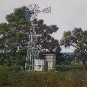 May include: A vintage windmill with a red and white sign that reads "The Acr. Motor Co.". The windmill is in a field with trees and a wooden water tank.