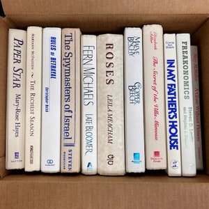 Puede incluir: Una colecci&oacute;n de diez libros de bolsillo con cubiertas blancas y t&iacute;tulos azules. Los t&iacute;tulos incluyen "Paper Star", "The Richest Season", "Rules of Betrayal", "The Spymasters of Israel", "Fern Michaels", "Roses", "Maeve Binchy", "The Secret of the Villa Mimosa", "In My Father's House" y "Freakonomics".