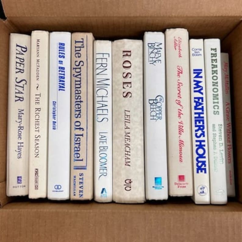 Puede incluir: Una colecci&oacute;n de diez libros de bolsillo con cubiertas blancas y t&iacute;tulos azules. Los t&iacute;tulos incluyen "Paper Star", "The Richest Season", "Rules of Betrayal", "The Spymasters of Israel", "Fern Michaels", "Roses", "Maeve Binchy", "The Secret of the Villa Mimosa", "In My Father's House" y "Freakonomics".