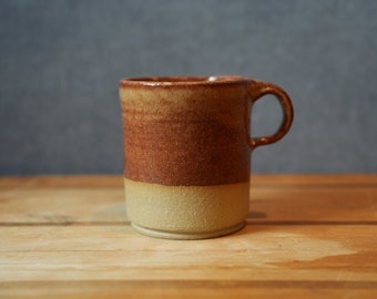 Handmade sandstone colored ceramic pottery coffee cup.