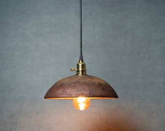 Round Raku fired hanging pendant light in matte copper with a flash of yellow
