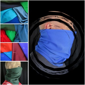May include: A blue neck gaiter made of a soft, stretchy fabric. The gaiter is shown folded and worn around the neck of a person.