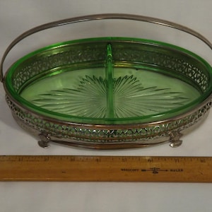 Puede incluir: Fuente ovalada dividida con interior de vidrio verde y borde y asa de filigrana de metal plateado. El plato tiene un patrón decorativo en forma de abanico en el vidrio y descansa sobre pequeños pies. Una pieza vintage.