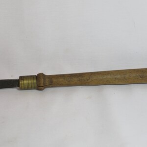 May include: A wooden handled metal tool with a brass ferrule. The tool has a flat, rectangular blade.