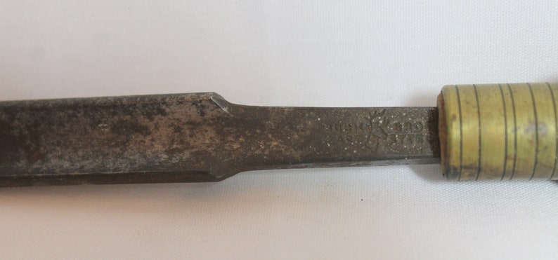 May include: A vintage wood chisel with a brass handle. The chisel is marked "Stanley No. 51/2".