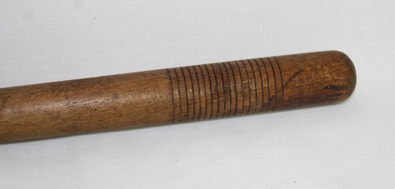 May include: A wooden rolling pin with a textured surface. The rolling pin is brown and has a smooth, rounded handle.