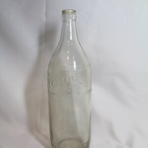 May include: A clear glass bottle with the word "Sequoia" embossed on the side. The bottle is empty and has a slightly textured surface.