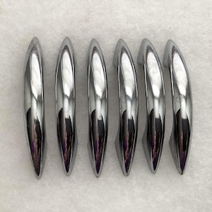 May include: A set of six polished chrome cabinet pulls arranged in a vertical row. Each handle features a smooth, curved, arching design with a reflective metallic finish and tapered ends, providing a sleek and uniform appearance for furniture.