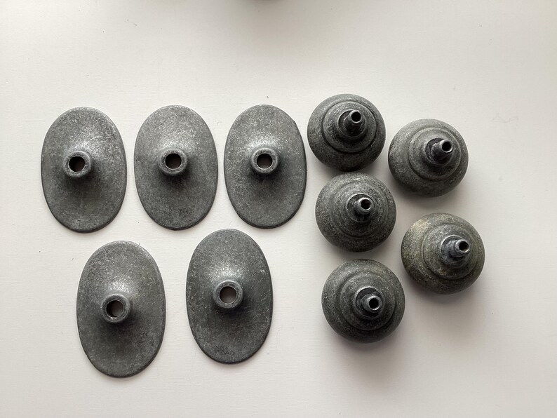 May include: A white ceramic mug with a black handle and the text "But First, Coffee" in a bold, black font. The mug is set against a blurred background, suggesting a cosy setting.