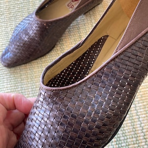 Puede incluir: Un par de bailarinas de cuero trenzado marr&oacute;n. Los zapatos tienen una punta afilada y un tac&oacute;n bajo. El interior del zapato es de color beige claro. Los zapatos est&aacute;n en buen estado y parecen ser vintage.