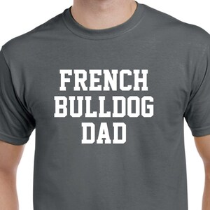 May include: A dark gray t-shirt with the text "French Bulldog Dad" in white.