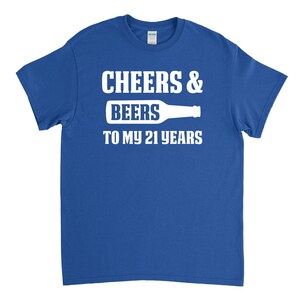 May include: A royal blue t-shirt with white text that reads "Cheers & Beers to my 21 years" with a white silhouette of a beer bottle.