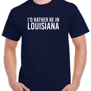 May include: A navy blue t-shirt with white text that reads "I'd rather be in Louisiana".