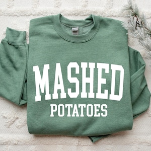 May include: A green sweatshirt with white text that reads "MASHED POTATOES".