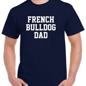 May include: A navy blue t-shirt with white text that reads "French Bulldog Dad".