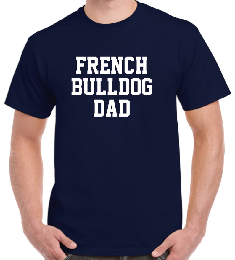 May include: A navy blue t-shirt with white text that reads "French Bulldog Dad".