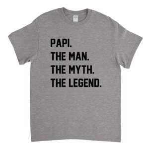 May include: Gray t-shirt with black text that reads "Papi. The Man. The Myth. The Legend."